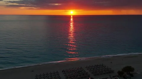 Aerial sunset over beach and calm sea with golden sun reflection on water Vidéo 336725225