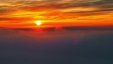 Aerial of sunset over a cloudy sky, painting the atmosphere in vibrant orange Stock Footage 305505947