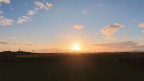 Aerial Sunset Over Green Fields and Wind Turbines in Rural Countryside Stock Footage 332431019