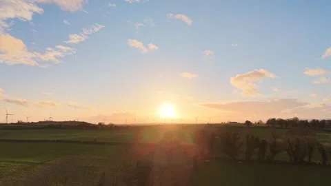 Aerial Sunset Over Green Fields and Wind Turbines in Rural Countryside Stock Footage 332431027