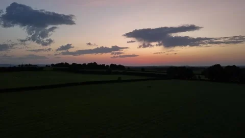 Aerial Sunset Over Green Fields and Rolling Countryside Stock Footage 332565662