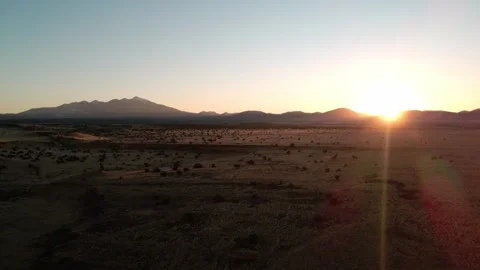 Aerial Sunset Over High Desert Rangeland and Snow-Dusted Peaks Vídeo Stock 304250457