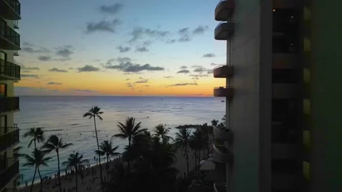 Aerial sunset over the ocean between Waikiki hotel towers, Hawaii Stock Footage 339633543