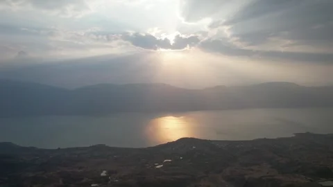 Aerial sunset over quiet lake surrounded by mountains in China Stock Footage 337675005