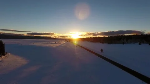 Aerial of sunset over snowy fields and a country road Stock Footage 71882398