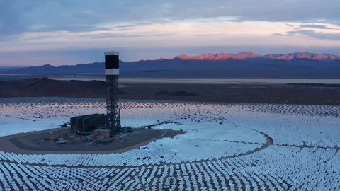Aerial sunset pullback shot of solar power towers, field of heliostat mirrors Stock Footage 121718955