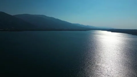 Aerial Sunset Reflection Across Calm Coastal Water Stock Footage 342345320