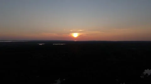 Aerial sunset then down to trees and water Stock Footage 251565035