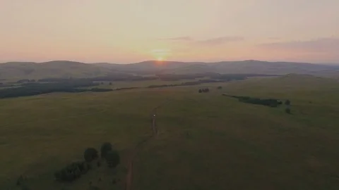 AERIAL:  Sunset at valley. The sun sets over the mountains on the horizon. 스톡 동영상 78032926