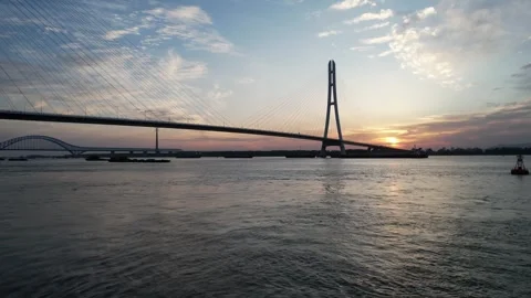 Aerial sunset view of modern bridge spanning wide river in China Stock Footage 337764967