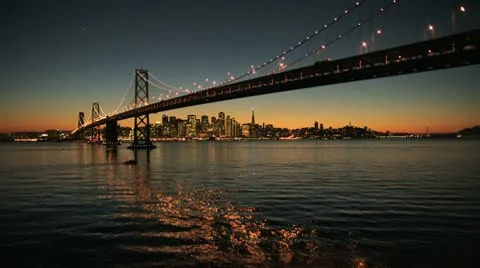Aerial sunset view under the illuminated Oakland Bay Bridge, San Francisco, USA Stock Footage 10715740