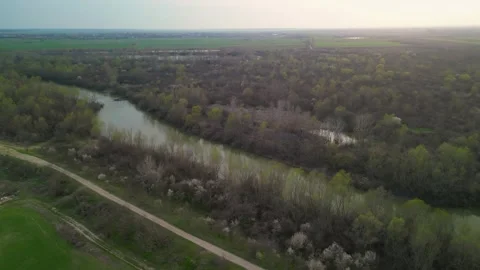 Aerial Sunset View of Winding River Through Forest in Early Spring Stock Footage 341400989