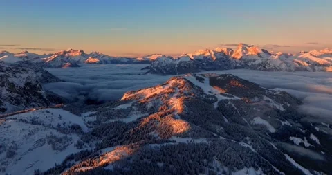 Aerial sunset view of winter mountain peaks and valley clouds in snowy alps. Video stock 339441520