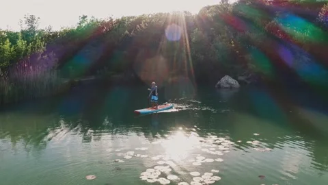 Aerial SUP surfer rows on small lake in mountains Stock-Footage 170411183