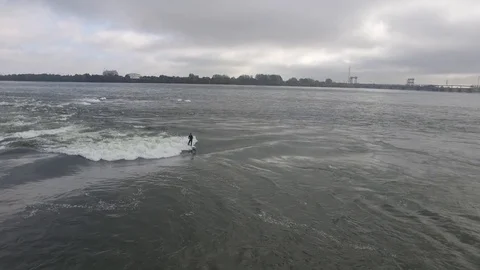 Aerial - Surfer enjoys the river surfing wave of Habitat 67, in Montreal. Stock Footage