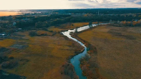 Aerial survey of a flight over a small river in the fall among yellowed plain Stock Footage 118061664