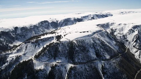 Aerial of switchback road climbing up mountain top covered with snow 스톡 동영상 124226039