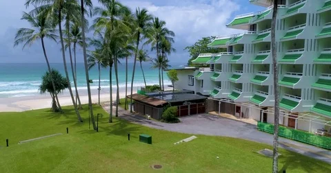 Aerial: Take off on a palm beach with white sand and green grass. Hotel resort. Stock Footage 80631714