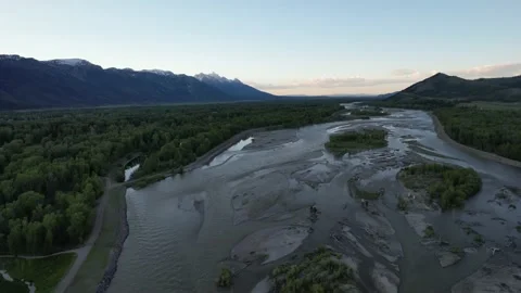 Aerial Teton Mountain Range Pull Back Over River At Sunset Vídeo Stock 233457450
