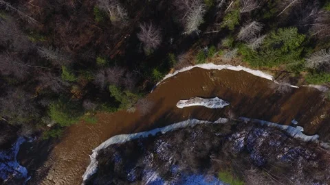 Aerial thaw on a brown river through Latvian boreal forest Stock Footage 331152644