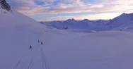 Aerial Of Three Adventurers Driving Snow Mobiles Over A Snowy Slope At Sunset Stock Footage