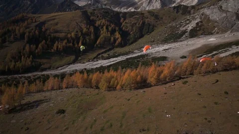 Aerial of three parachutes flying over the autumn tree in the mountains Stock Footage