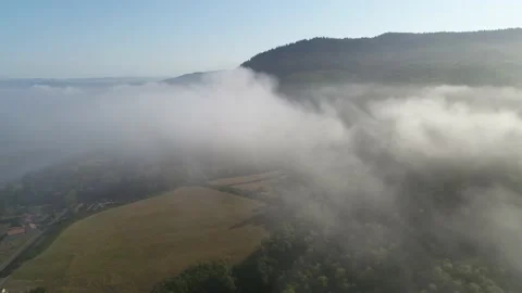 Aerial through low clouds above rural farmland near Tillamook, Oregon at sunrise Stock Footage 219349430