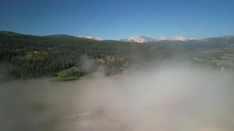Aerial through low clouds above meadow in Montana Madison Range Stock Footage 282834202