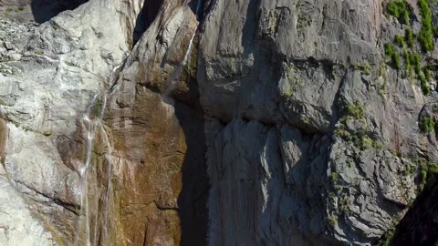 Aerial tilt down over a waterfall in a rocky mountain Video stock 152033686