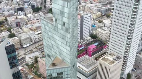 Aerial Tilt Down Shot Of Modern Skyscraper Amidst Vehicles On Streets, Drone Stock Footage 240957779