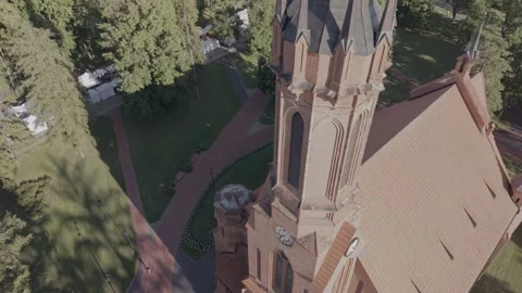 Aerial Tilt Down View of Gothic Red Brick Church Spire with Clock Stock Footage 342202614