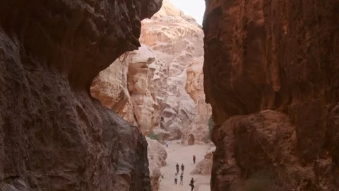 Aerial tilt down view Little Petra Jordan canyon with tourists walking in m.. Video stock 341271504