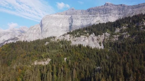 Aerial tilt down view from a mountain range to a green lake. Video stock 140782488