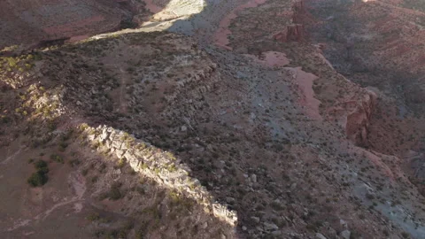 Aerial tilt to reveal dramatic mesa in a desert canyon at sunset Stock Footage 133770286