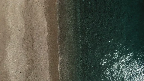 Aerial tilt up view for a sandy beach revealing the town of Taormina in Sicily Stock Footage 105687294