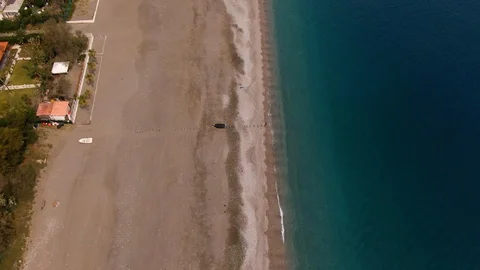 Aerial tilt up view from a sandy beach revealing the town of Taormina in Sicily Stock Footage 106400438