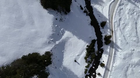 Aerial tilt up from winter forest stream to snowy mountain valley, 4K 60fps Vídeos de archivo 329504474
