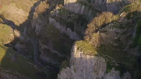 Aerial tilting down over the exposed limestone cliff-tops and road beneath at Vídeos de archivo 250790736
