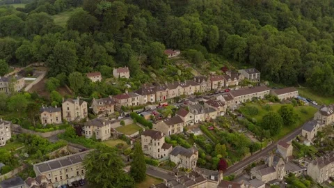 Aerial tilting down over row of fine English houses set amongst verdant green Stock Footage 144782798