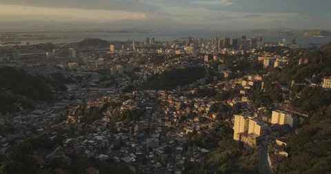 Aerial tilting down towards favela with downtown Rio de Janeiro and Guuanabara 스톡 동영상 101288537
