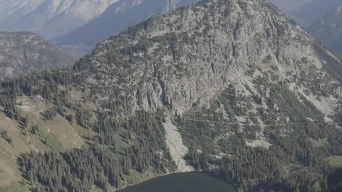 Aerial tilts down over Lake Ann from the mountains in North Cascades, Washington Stock Footage 345172440