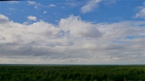 Aerial time lapse of blue sky and clouds over green summer forest Stock-Footage 66240786