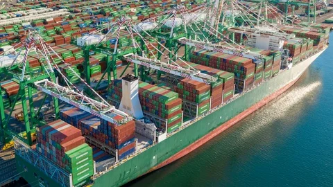 Aerial time lapse of container ship unloading cargo containers with cranes Stock Footage 99011439