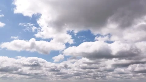 Aerial time-lapse of fast-moving white puffy cumulus clouds on a beautiful blue Stock Footage 280999999