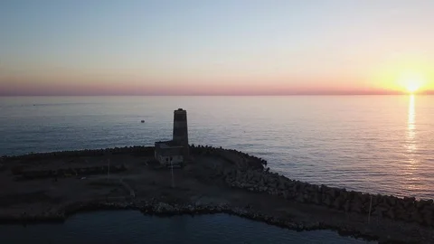 Aerial Time Lapse An old abandoned lighthouse on the sea against the sunset Stock Footage 98315515
