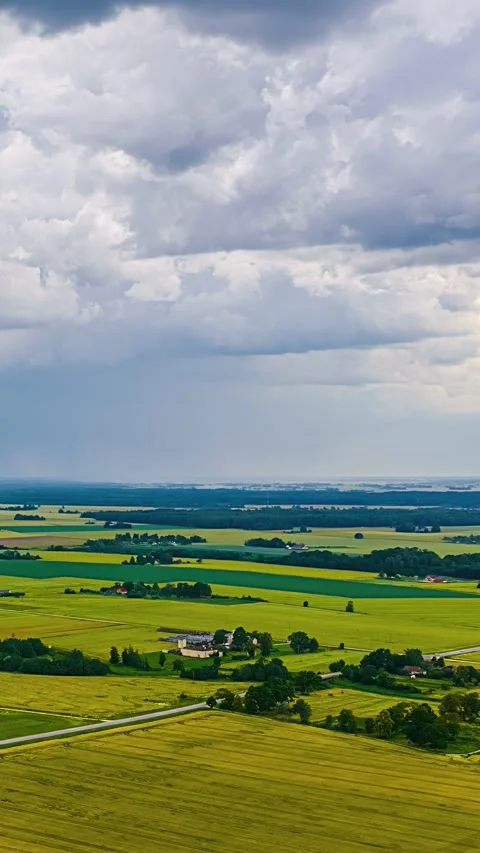 Aerial Time Lapse of Rain Clouds over Yellow and Green Farmland Patchwork Stock Footage 347972561