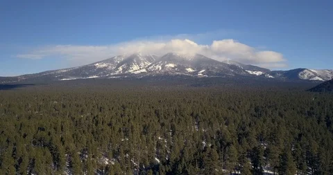 Aerial Timelapse of clouds boiling and rolling over snowy mountain peaks Video stock 101617021