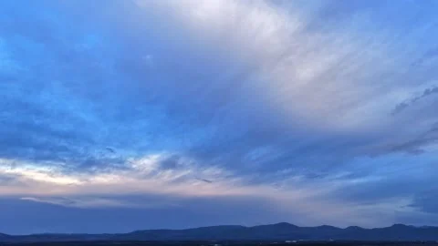 Aerial Timelapse of Diffuse Clouds Over Mountains as Evening Light Shifts Stock Footage 336949320