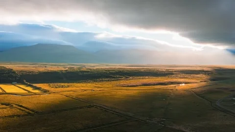 Aerial timelapse of golden fields and distant mountains, Iceland Stock Footage 340631611