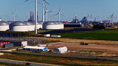 Aerial timelapse of storage tanks wind turbines solar panels and excavator in Stock Footage 344512748
